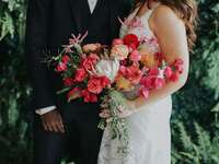 bride holding protea and bougainvillea bouquet