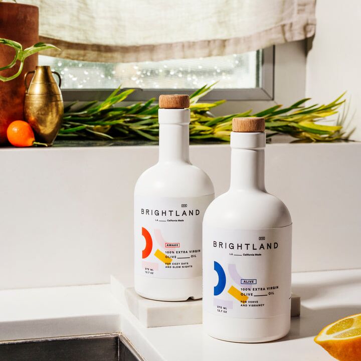 Two bottles of gourmet olive oil sit on a counter top. 