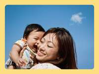 Mom holding baby against a blue sky