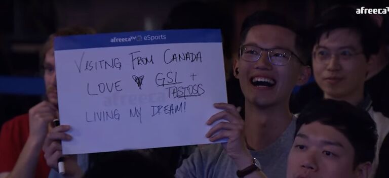 Alec and Nancy at the Global StarCraft League in Korea. 

Not pictured: Nancy because she is being savagely blocked by Alec's sign. 

Alec got shouted out by Tastosis though, so worth??? 

(No.)