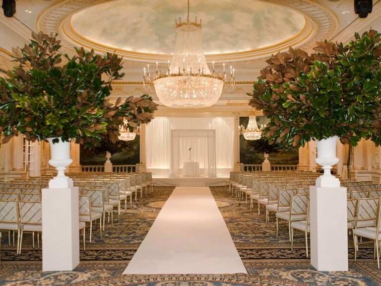 Indoor ceremony site with a grand crystal chandelier and marble ceiling