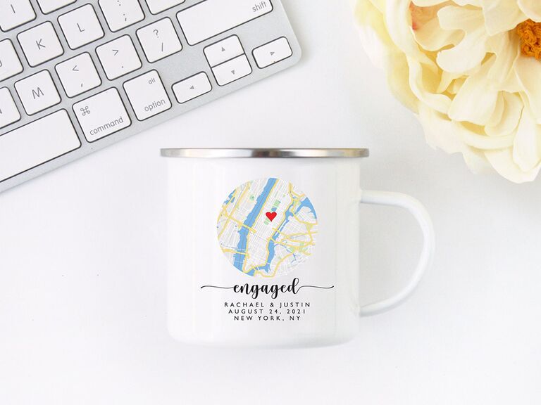 Circle map with heart graphic and 'engaged' in black script with personalized names on white mug