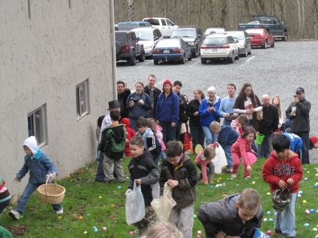 Here are little Kendra and Hayden, too engrossed in the Easter festivities to notice one another. Hayden, in a blue jacket, is behind Kendra in bright pink with a pink bucket. (Matron of Honor Kaimee is also in the photo with the big basket and white hood!)