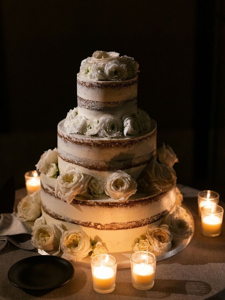 classic three tier semi naked wedding cake with white roses and votive candles