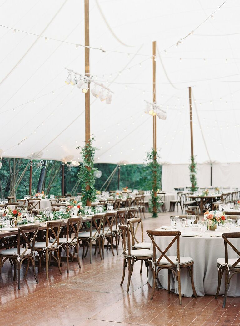 Rustic tented wedding reception with wood cross-back chairs