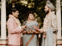 Grooms reading vows with an interfaith officiant's guidance.