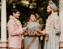 Grooms reading vows with an interfaith officiant's guidance.