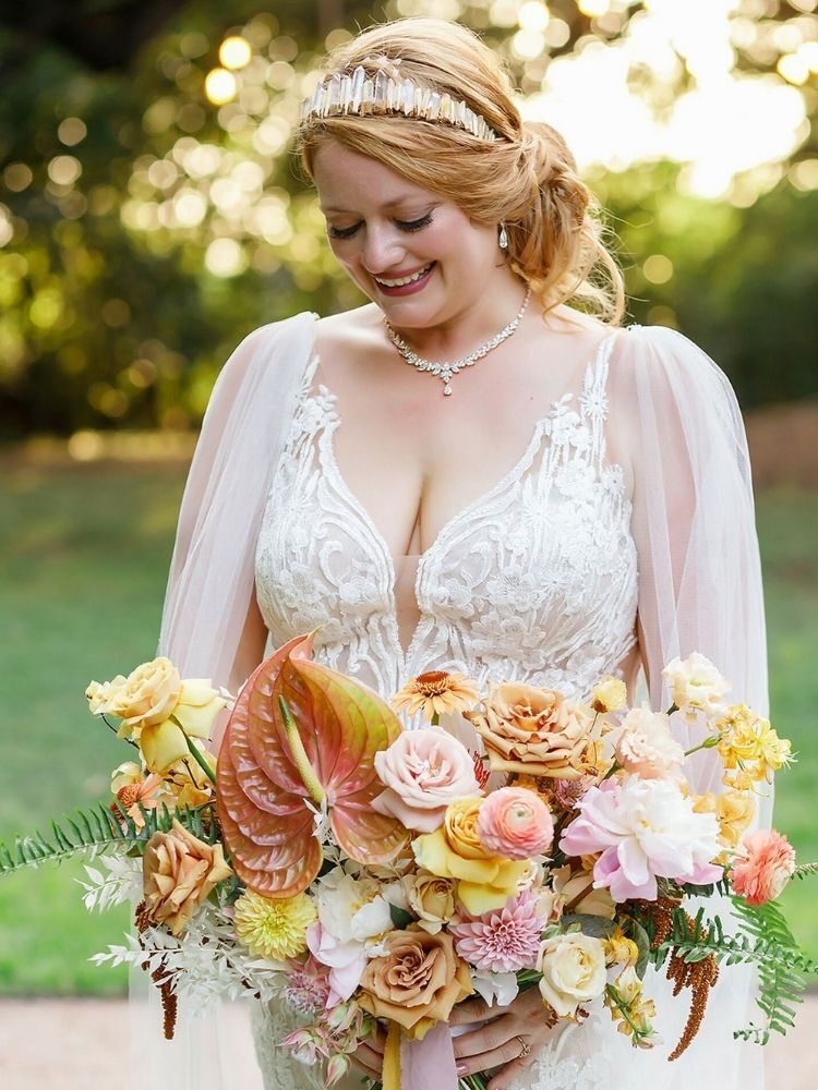 bride holding peach-hued anthurium and rose bouquet