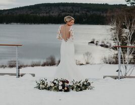 Woman showing the back of her wedding dress in the snowy landscape