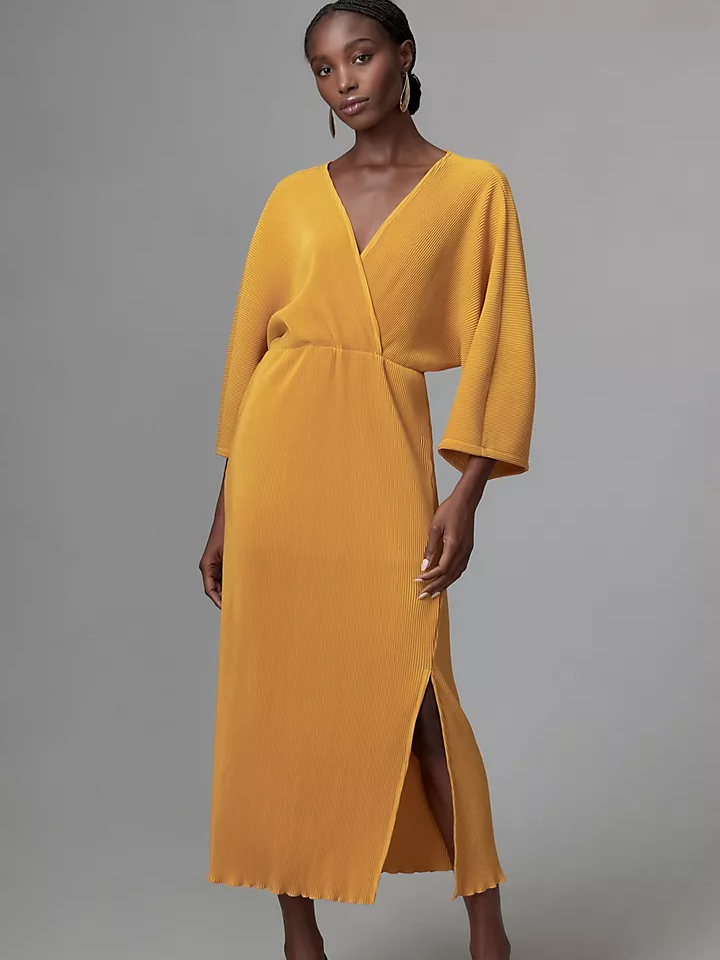 Model wearing a v-neck wrap midi dress in a mustard hue