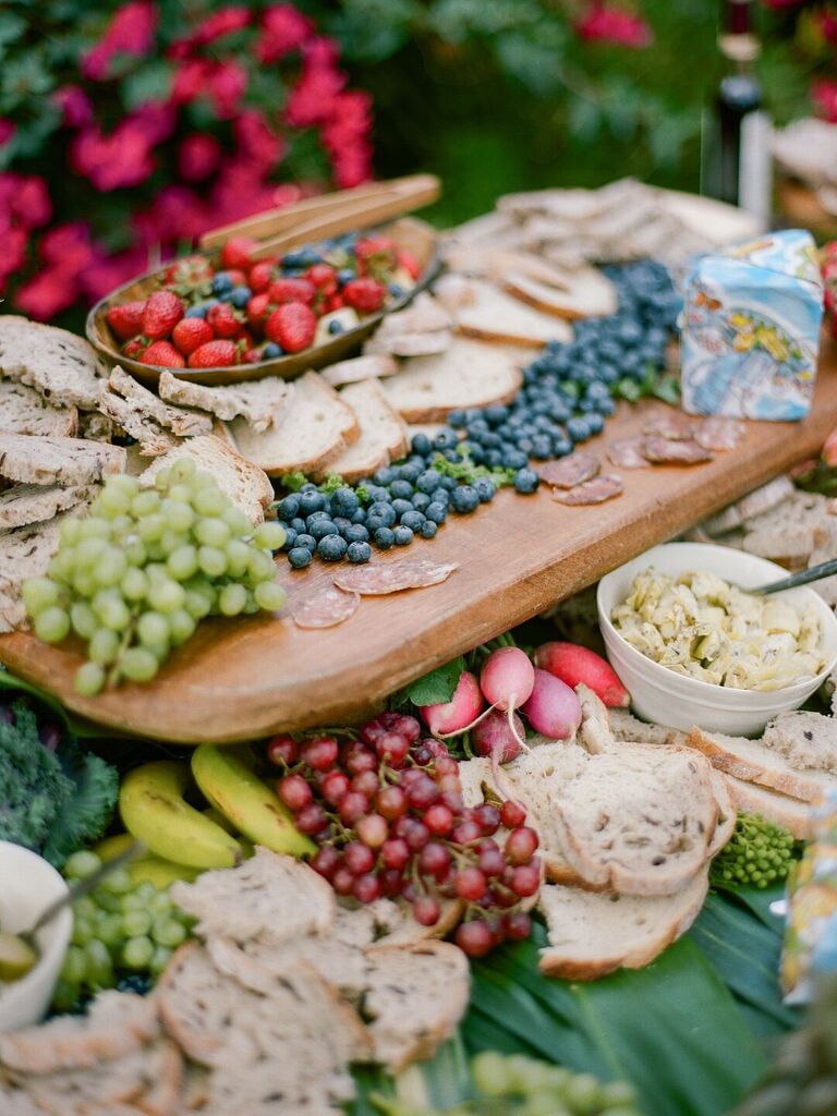 Fruits, dips and other small bites grazing table at wedding