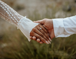 Couple holding hands with engagement ring on