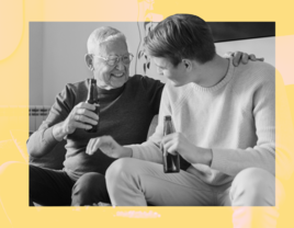 Two men smiling and enjoying a drink from glass bottles