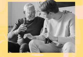 Two men smiling and enjoying a drink from glass bottles