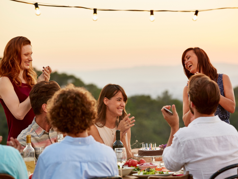 Friends clapping while enjoying dinner party