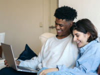 Couple using laptop together at home