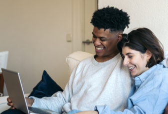 Couple using laptop together at home