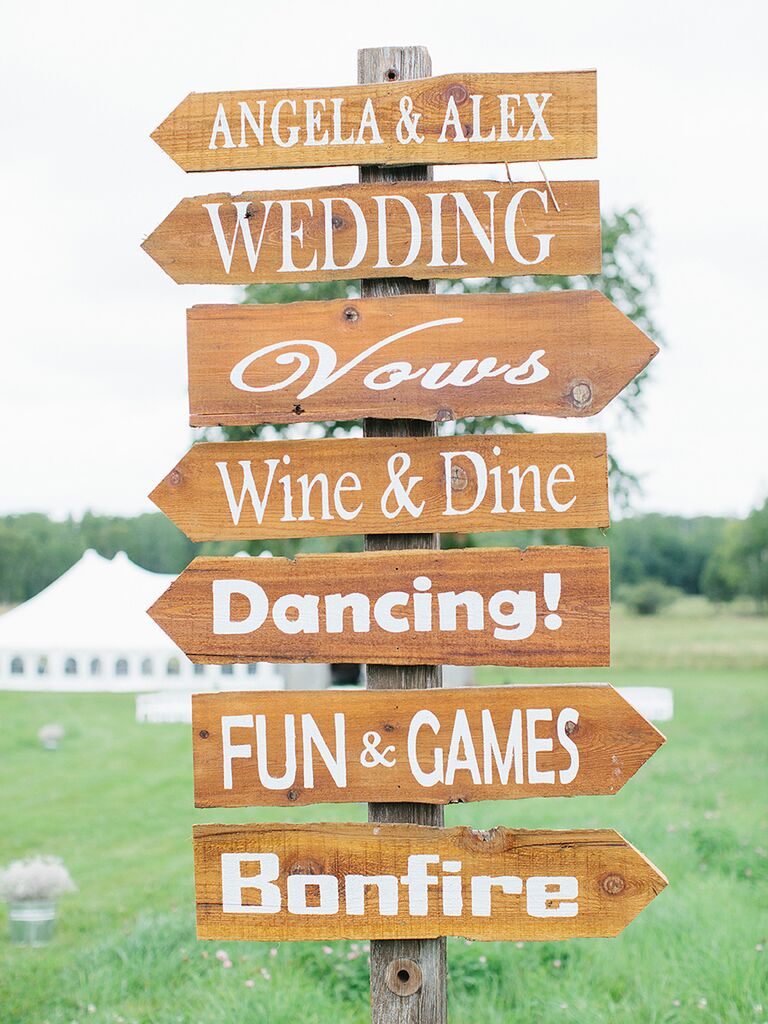 Wood wedding sign pointing to activities for guests