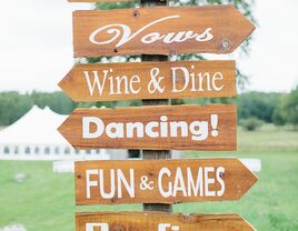 Wood wedding sign pointing to activities for guests