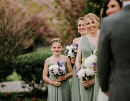 junior maid of honor standing with bridal party at wedding