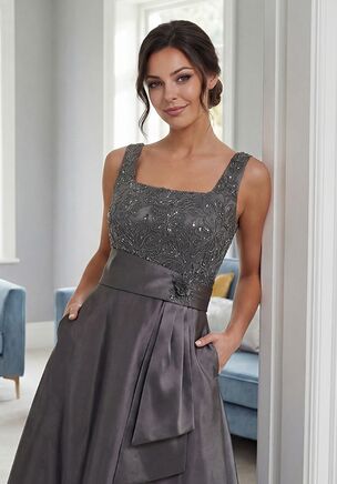 Polished and fashion-forward, this Mikado A-line gown is a striking choice for the Mother of the Bride. The sequin Embroidery Lace bodice features wide straps and a clean square neckline, creating a structured and flattering silhouette. A wide waistband with a fabric fold accent defines the waist beautifully, while the A-line skirt flows with graceful volume, delivering a look that is confident, sophisticated, and unforgettable.