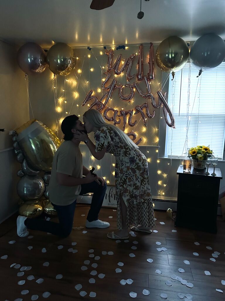 The day after closing on their first home, Mitch secretly left work early to set up his proposal for Julia. Julia found this surprise as soon as she unlocked the front door and walked into the house. Of course she said YES!