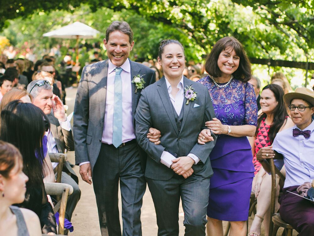 Bride walking down the aisle with mother and father