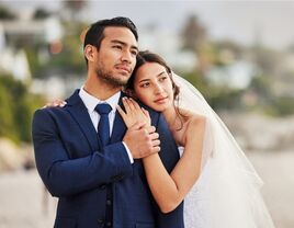 Happy couple holding onto each other for a wedding portrait