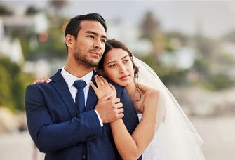 Happy couple holding onto each other for a wedding portrait