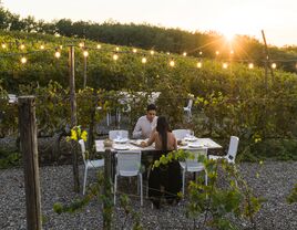 Young couple having dinner in a vineyard in Italy, Tuscany, Siena.