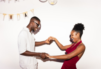 Couple holdings hands in front of birthday decor, unique birthday date ideas