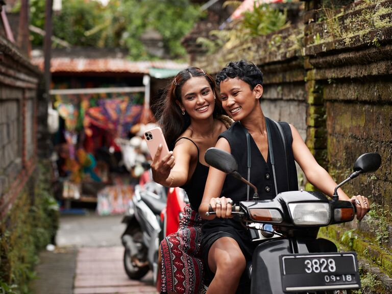 Couple taking selfie on scooter ride in bali