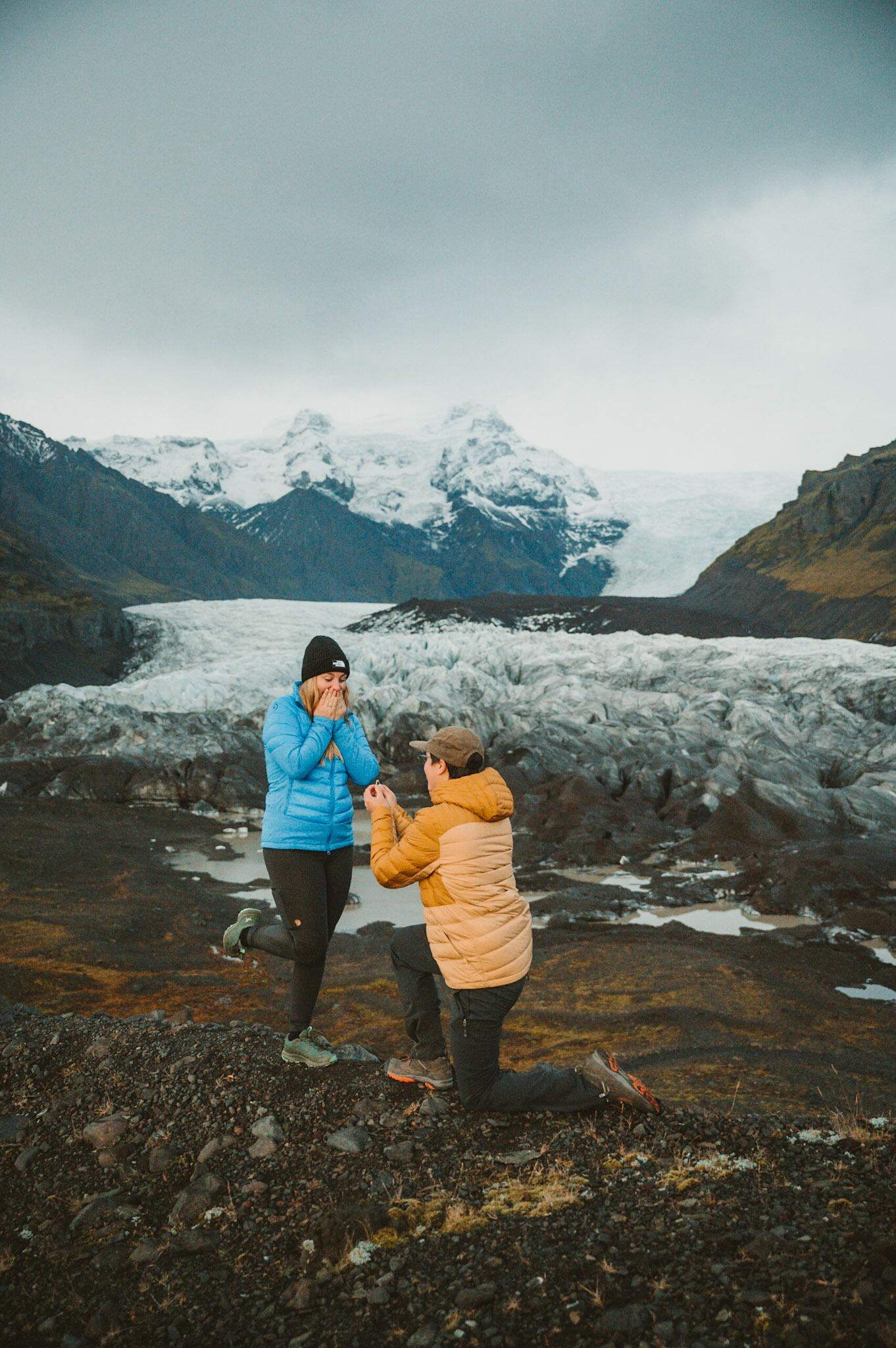 To celebrate Landon’s 25th birthday (and also for a well deserved vacation) Ruby planned a trip to one of their bucket list locations; Iceland! This trip ended up being their first international trip together and filled with all of their favorite activities: road trips, hiking, fun new foods, and exploring new areas. Despite the trip being Ruby’s surprise to Landon for his birthday, Landon flipped the surprise around and proposed! It was a few days into the trip and they made an unplanned stop at a glacier for a sunset hike. They were practically the only ones in the area and spent the majority of the time laughing and joking around as they explored. On a ridgeline with a beautiful view, Landon suggested they take some pictures and set up his tripod. After a few classic poses and just goofing around, he went to “change the settings” on the camera. Once he came back to the spot where Ruby was, they posed for a standing photo. After a few moments went by they both relaxed their pose and Landon dropped down to one knee and started to tie his shoe. Ruby giggled for a moment thinking he was playing a joke, but then was stunned when he looked back up at her with a beautiful ring and asked her to marry him. It was perfect.