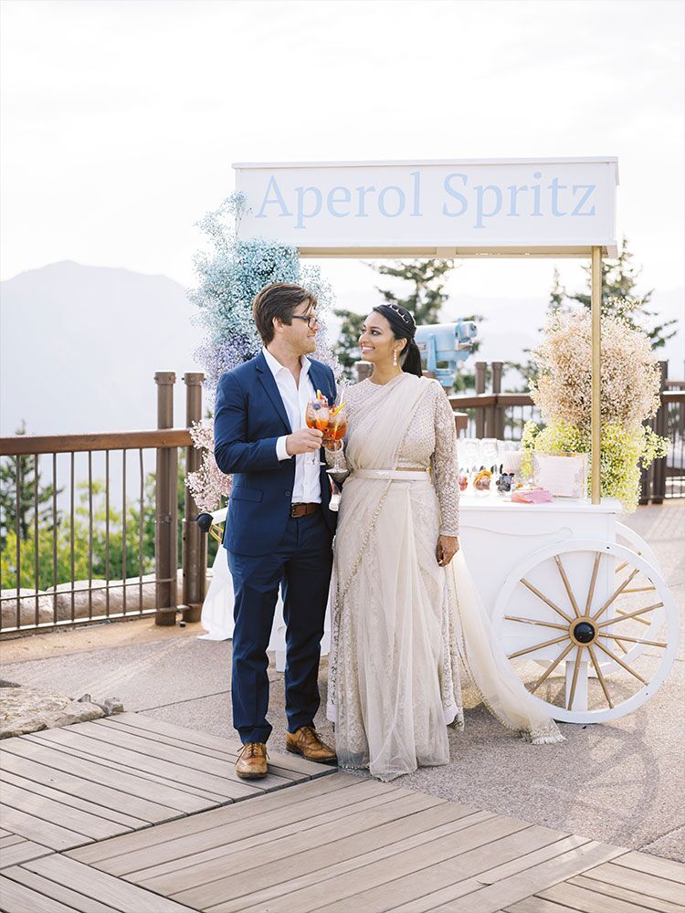 couple toasting with aperol spritzes