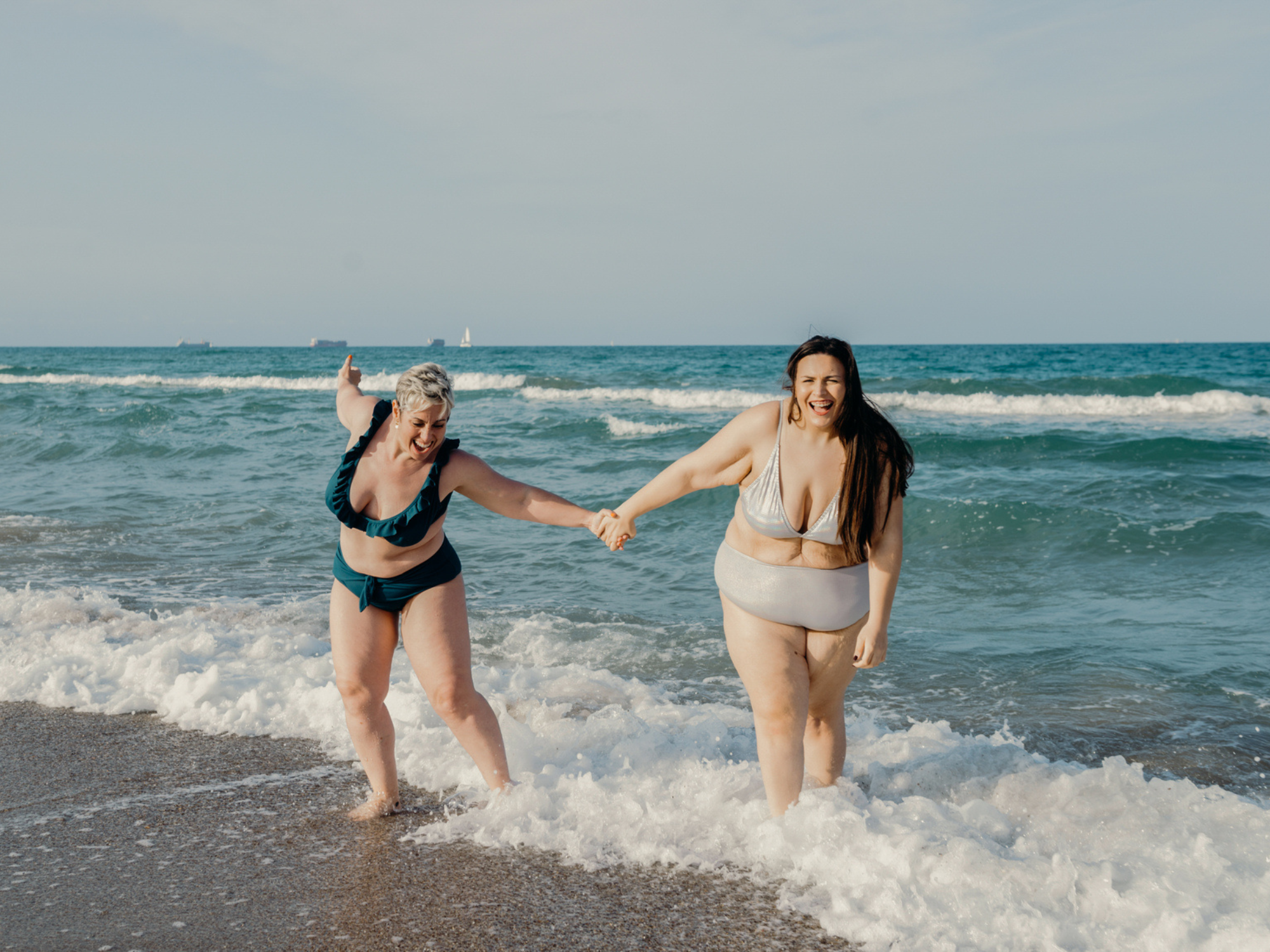 Couple holding hands standing in ocean, best honeymoon destinations in January
