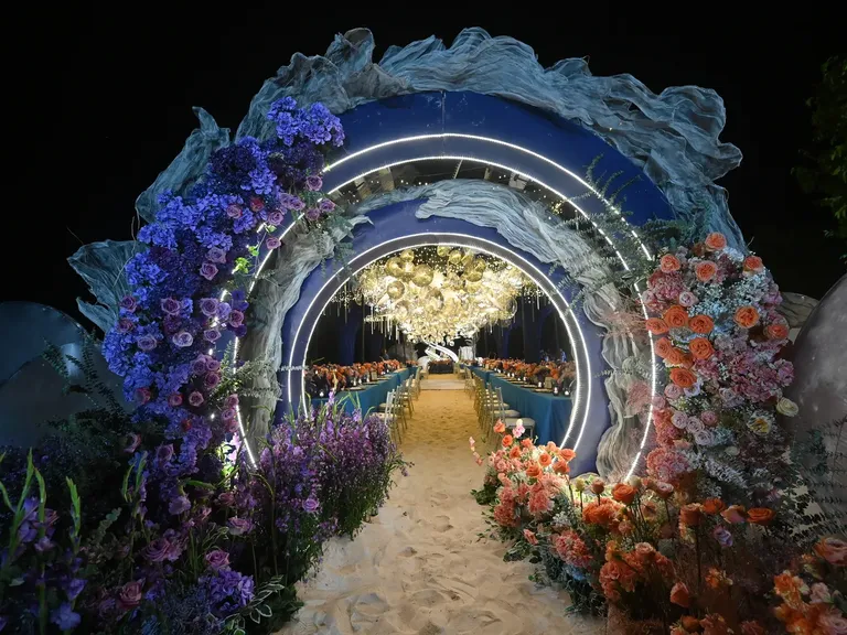 Floral Reception Tunnel With Blend of Colors Leads to Outdoor Dinner