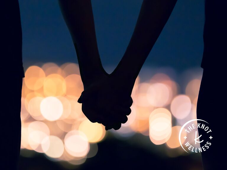 couple holding hands in bright lights