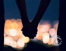 couple holding hands in bright lights