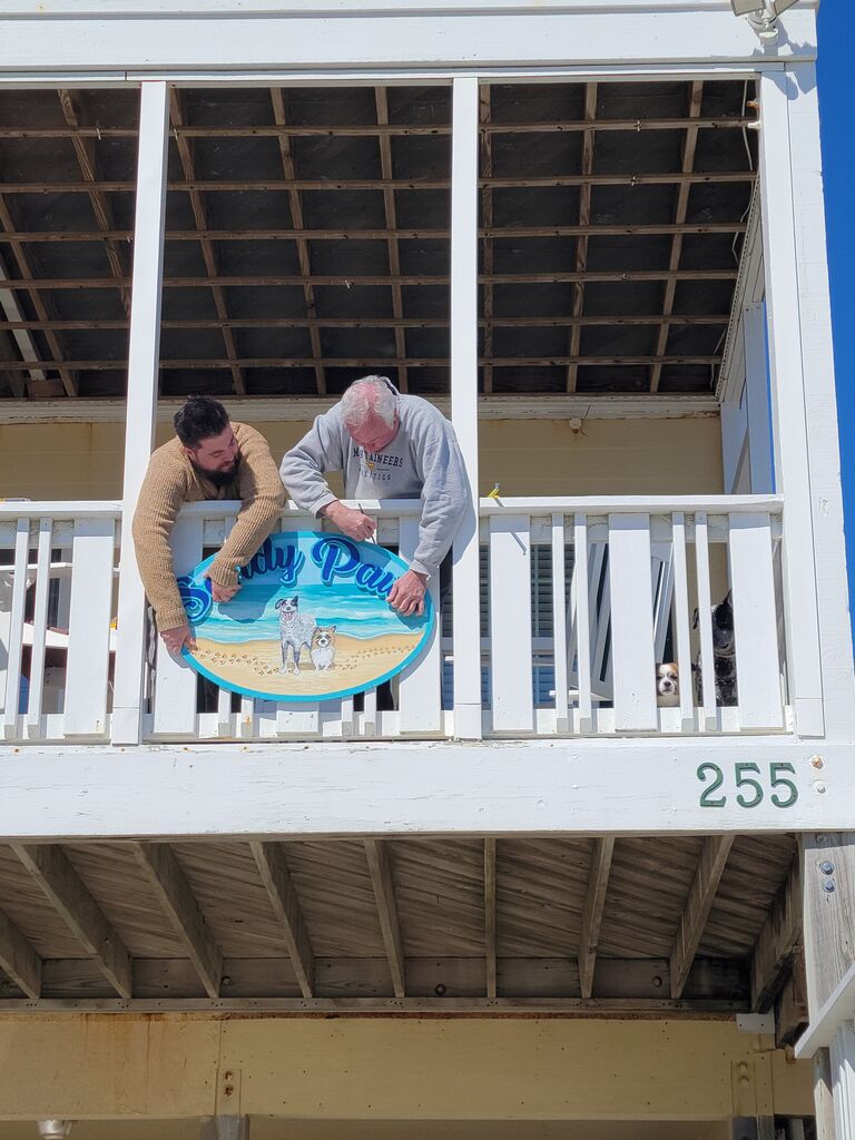 Our first beach trip. Dave put Bryan to work hanging the new Sandy Paws sign