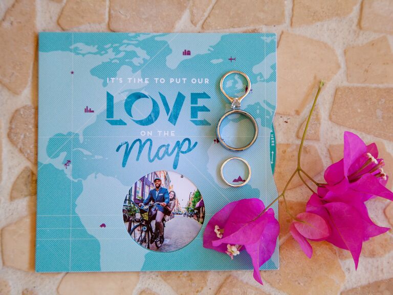 travel themed wedding invitation with a map and photo of the couple riding a bike