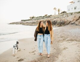 same sex couple walking on beach