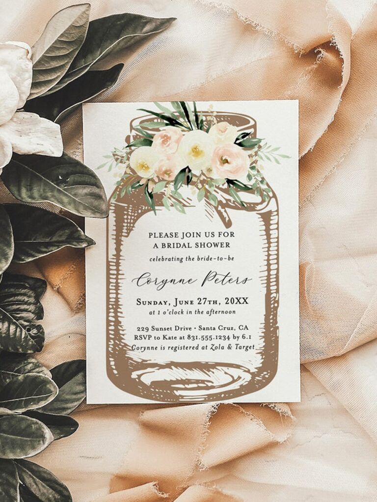 Rustic mason jar design with flowers and event details in middle