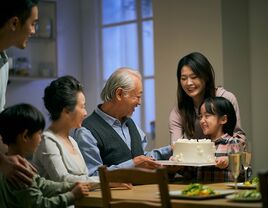 Family enjoying birthday cake around a dinner table