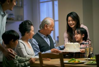 Family enjoying birthday cake around a dinner table