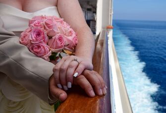 Newlywed couple holding hands on a cruise