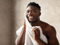 Man wiping face with towel, men's grooming tips for wedding