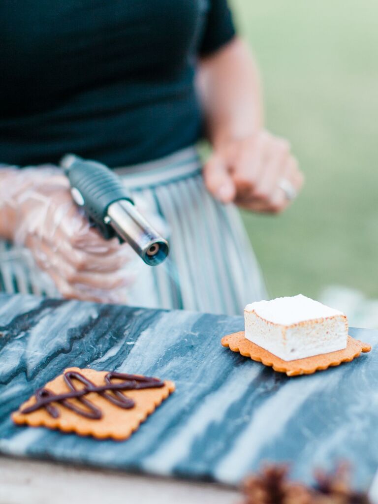 Chef toasts a marshmallow to create a gourmet s'mores. 