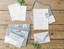 White wedding invitation suite with slate blue envelopes and retro stamps. 