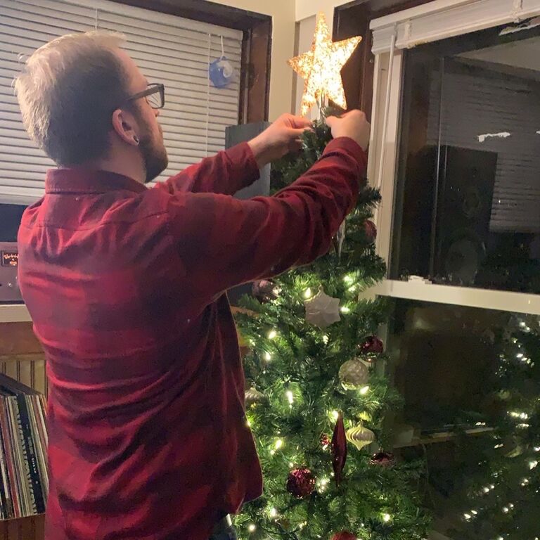 Austin gives in to setting up our first Christmas tree together.
