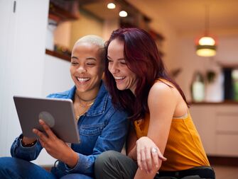 Couple smiling and using tablet computer
